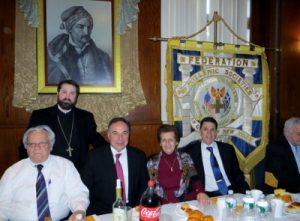 –  Dr. Spiros P. Katsifis, (left to right) Chairperson of the Department of Biology, University of Bridgeport, Dr. John Angelidis, professor of J. Tobin School of Business, St. John’s University;  Father Meletios (standing) and associates at the luncheon.