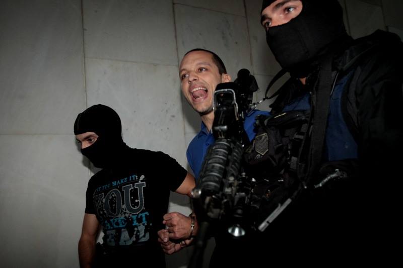 Golden Dawn spokesman Ilias Kasidiaris screaming as he's escorted in handcuffs by police