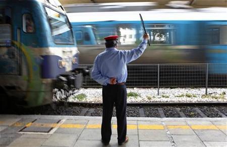 A Greek railway employee signals for trains at Athens main train station