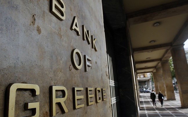 Pedestrians walk past the bank of Greece in Athen