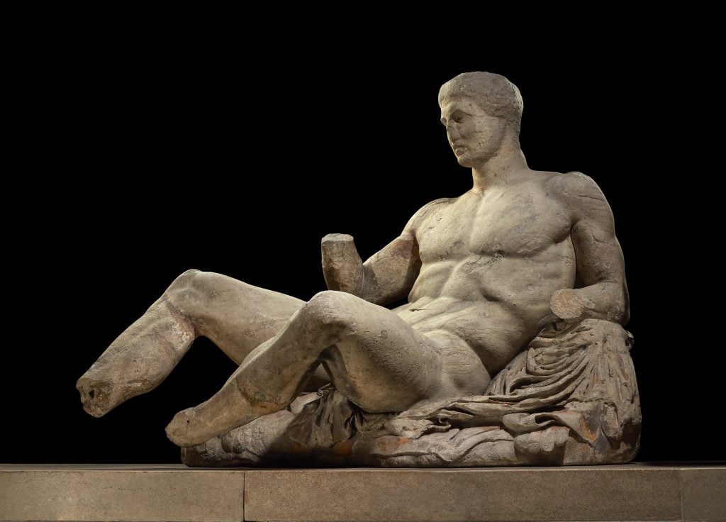 A figure of a naked man, possibly Dionysos.  Marble statue from the East pediment of the Parthenon.  Designed by Phidias, Athens, Greece, 438BC-432BC.  Height 127cm x 174cm.  © The Trustees of the British Museum. 