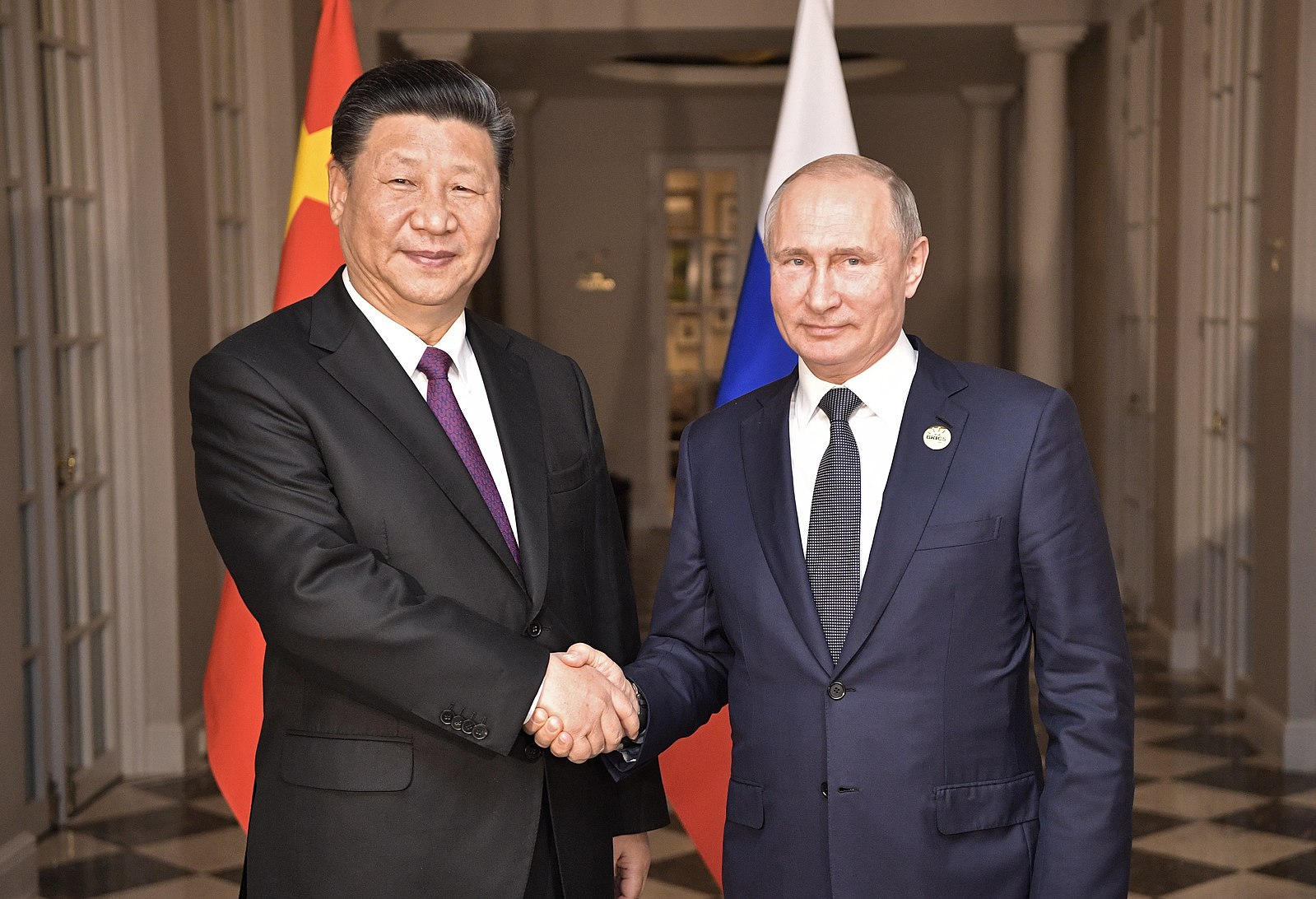 Russian President Vladimir Putin and Chinese President Xi Jinping shake hands