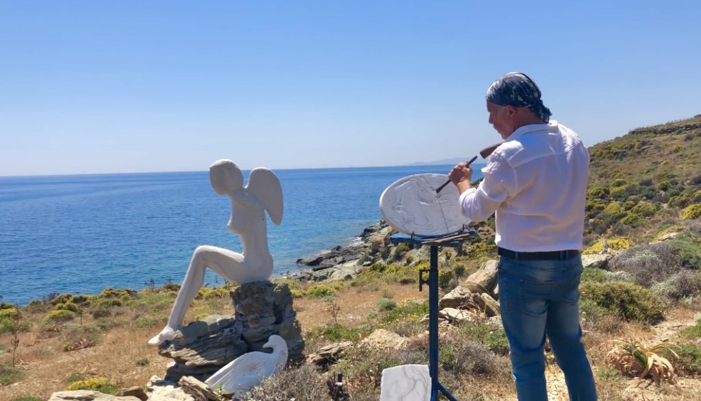 A sculptor working next to the sea.