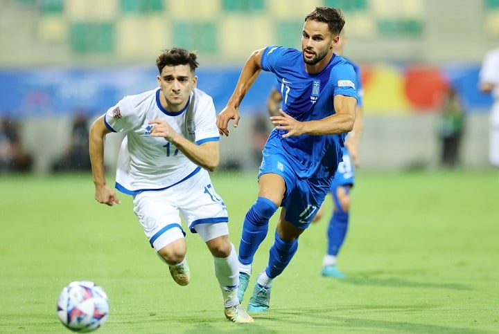 Two football players of the Greece and Cyprus national teams competing.