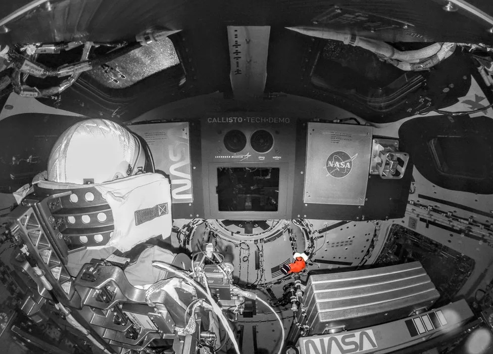 Inside uncrewed Orion with manikins and a Snoopy mascot (orange).