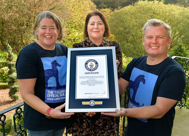 Animated Objects Theatre Company team hold Guinness World Record certificate for World's biggest cardboard sculpture.