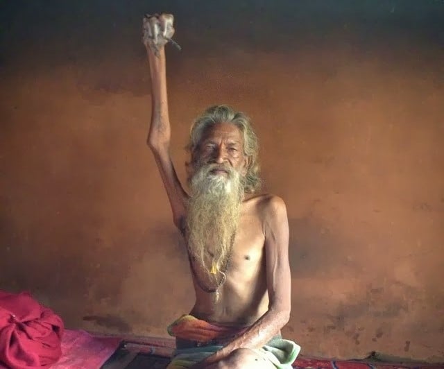 Amar Bharati an Indian Ascetic Hindu Yogi Sadhu Naga holds his hand up for universal peace