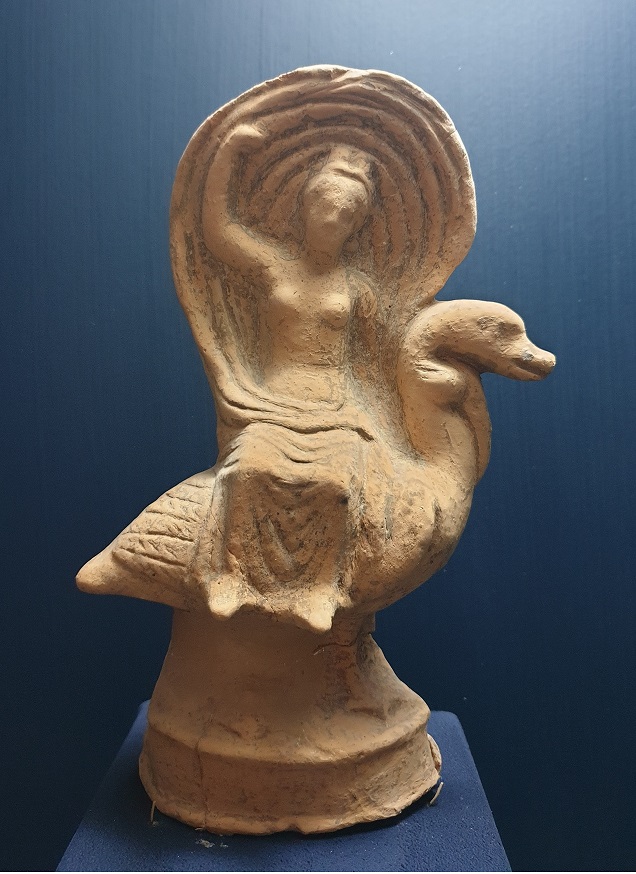 Ancient figurine of woman sitting on swan. 