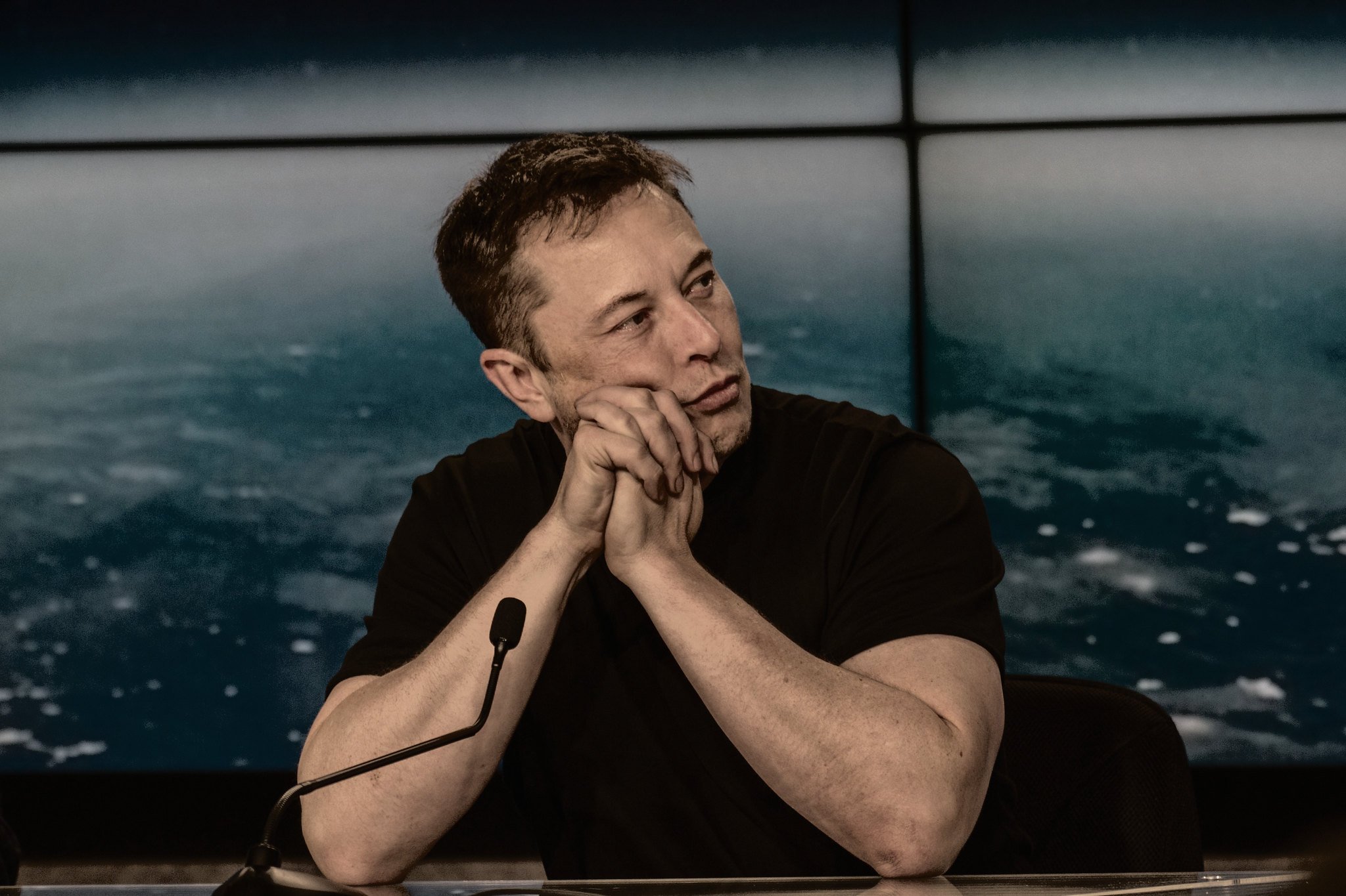 elon musk clasping his hands with a concerned or concentrated look