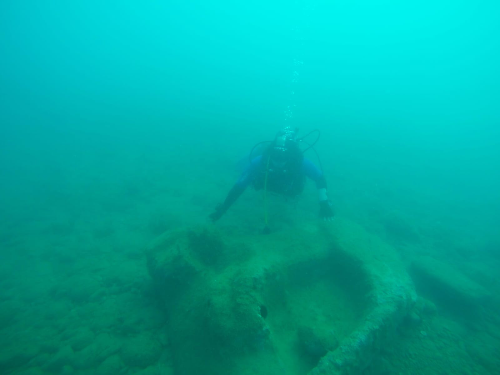 Diver exploring the relief of the Olympian Temple of Zeus in the seabed in Agrigento, Italy.