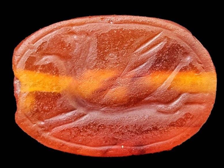 Orange amulet or 'scarab' believed to be from the Assyrian period, discovered in Israel.