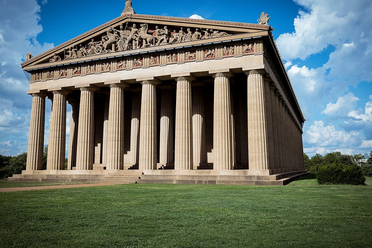 A full-scale replica of the Parthenon in Centennial Park, Nashville, under a partly cloudy sky.