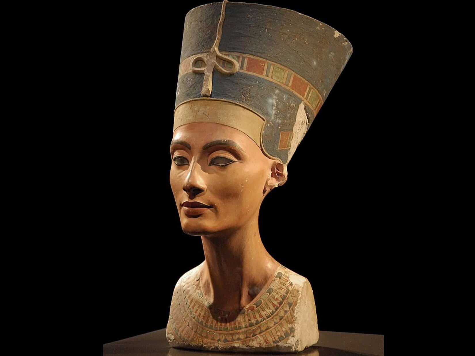 Portrait bust of Queen Nefertiti with her distinctive blue crown, showcasing her regal features and timeless beauty, on display at the Neues Museum in Berlin.