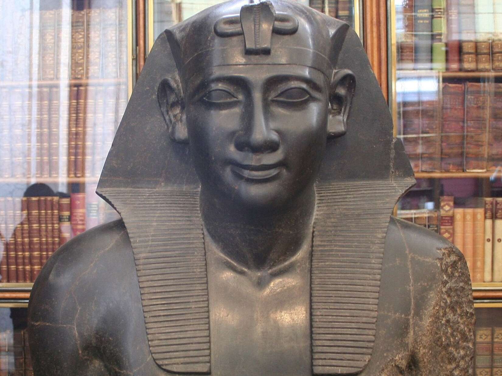 Statue of Ptolemy depicted as an Egyptian pharaoh, merging ancient Greek and Egyptian royal iconography, denoting an exchange of cultures.