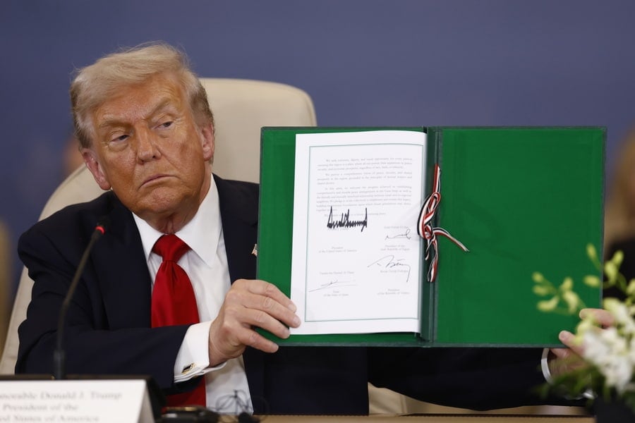 US President Donald Trump shows a signed document at the Gaza Peace Summit in Sharm El-Sheikh, Egypt.
