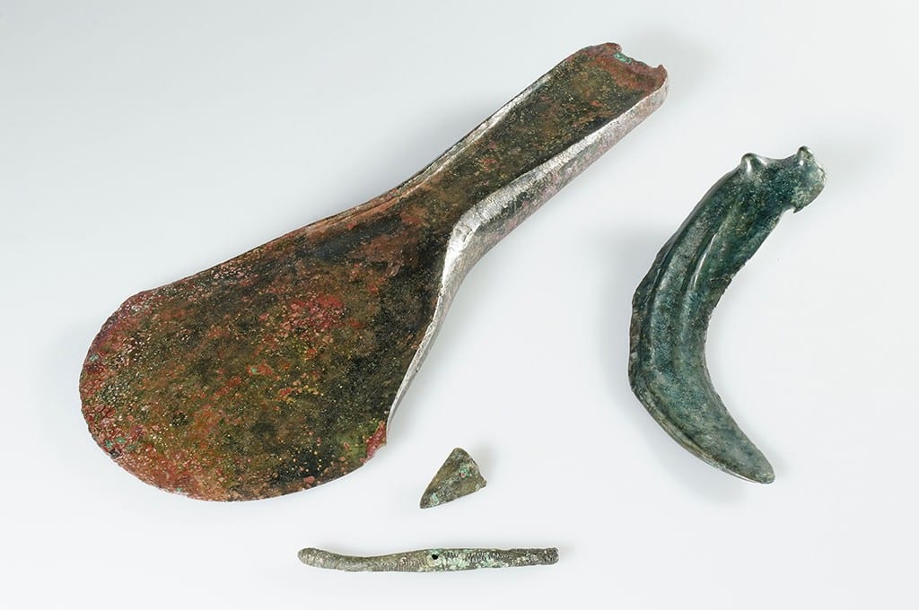A flanged axe, a knob sickle, a needle, and a fragment of an arrowhead