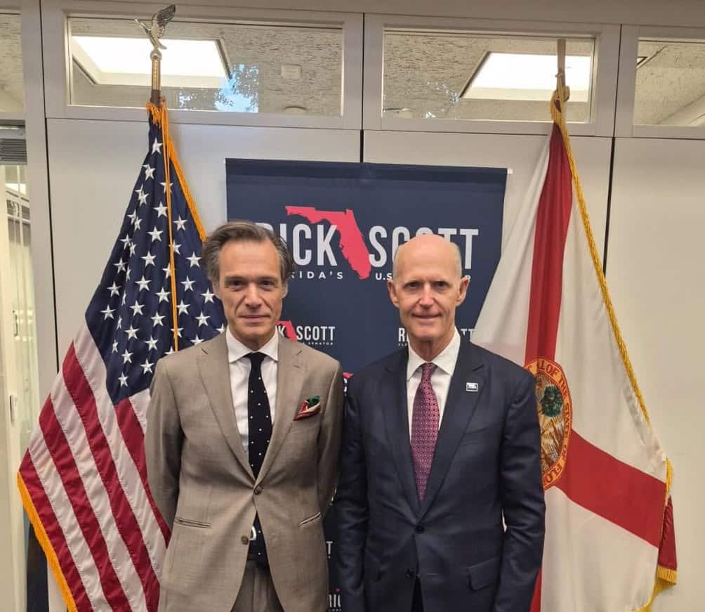 Greek Ambassador to the United States Antonis Alexandridis stands with US Senator Rick Scott in front of the American flag