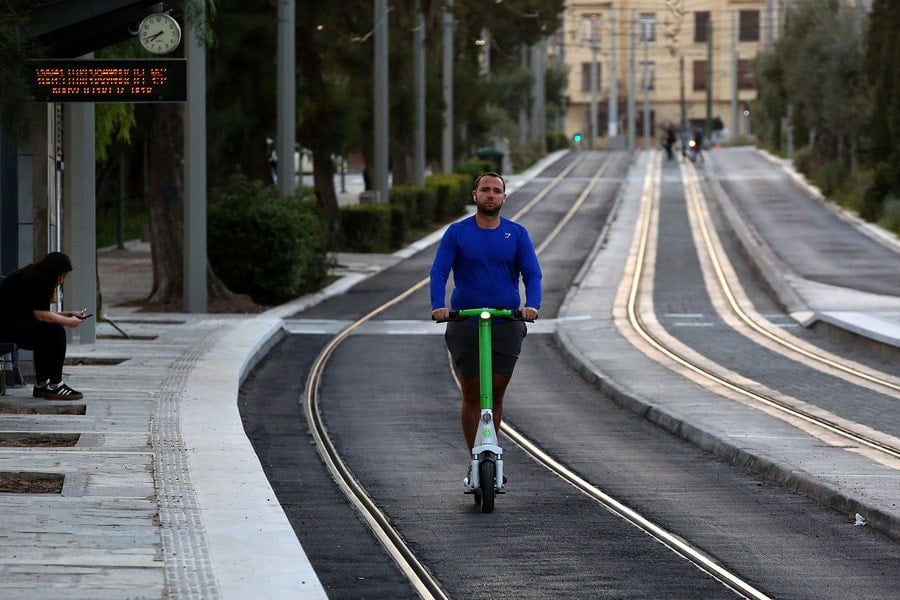 An e-scooter rider travels along tram tracks in Athens, Greece, as the country introduces stricter rules for electric scooter use.