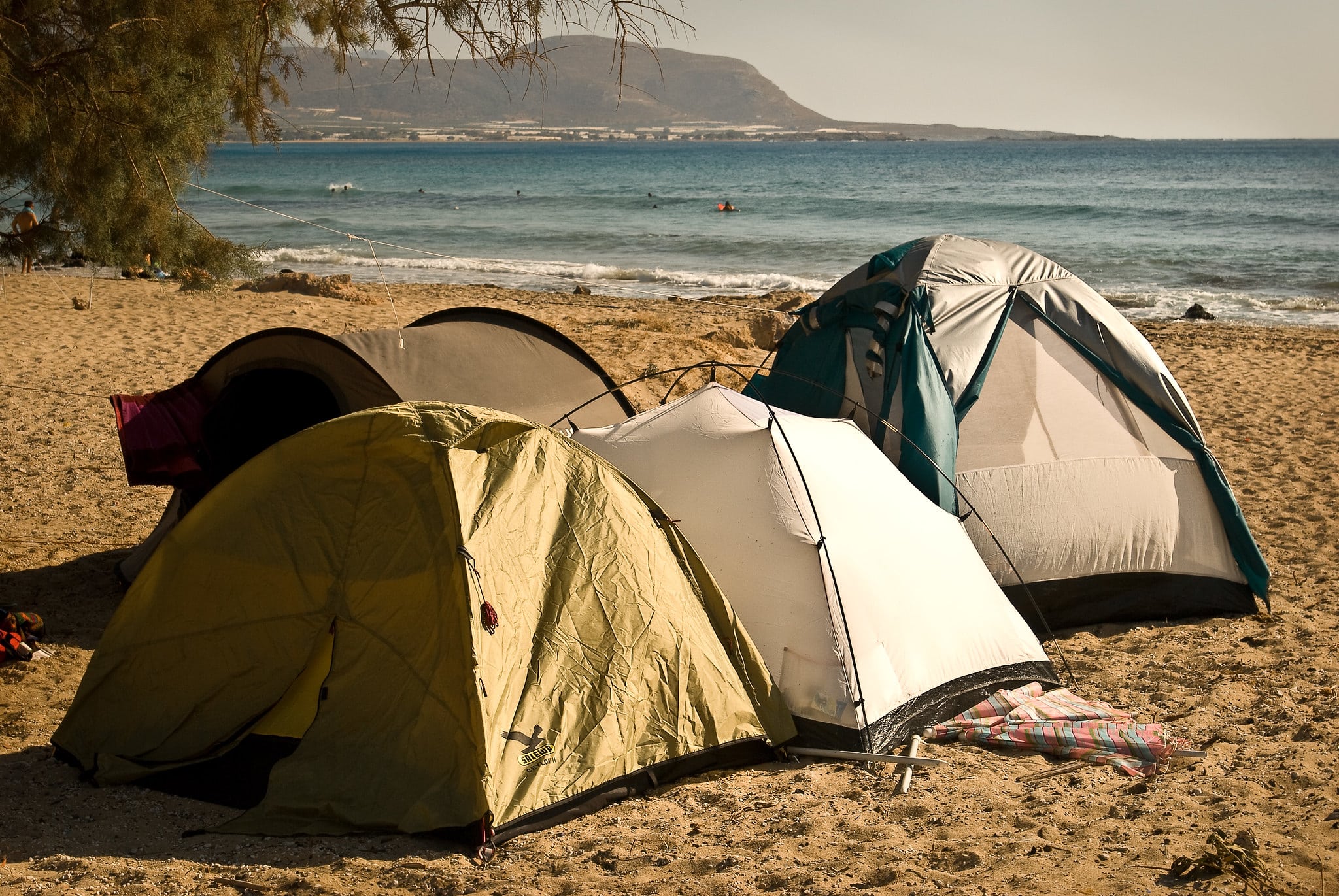 Tents set up for free camping on Falasarna beach in Crete, Greece.