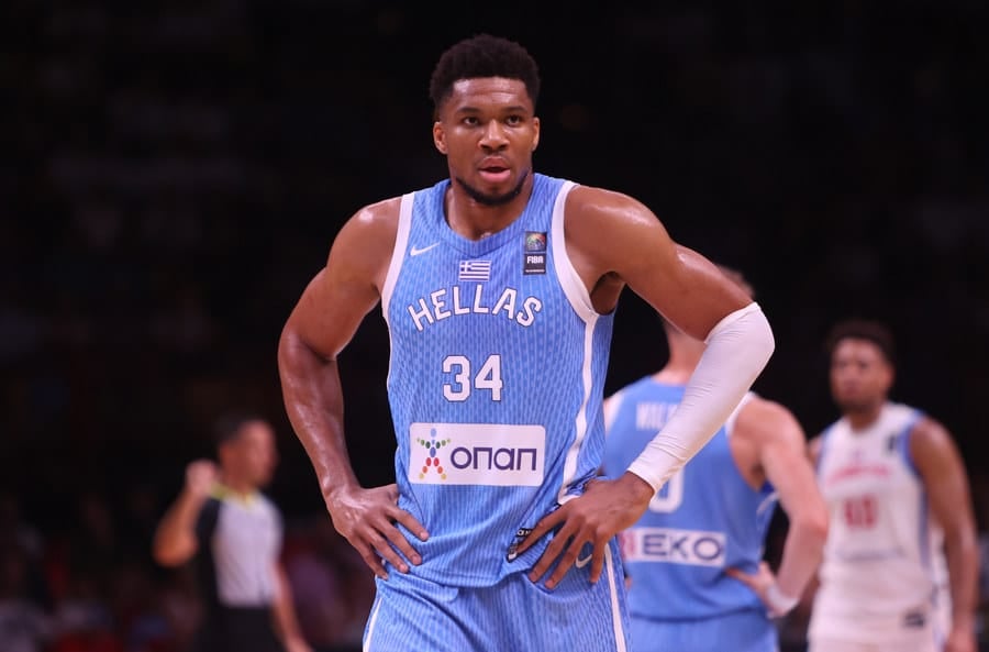 Giannis Antetokounmpo wearing Greece’s national basketball team jersey on the court during a game.