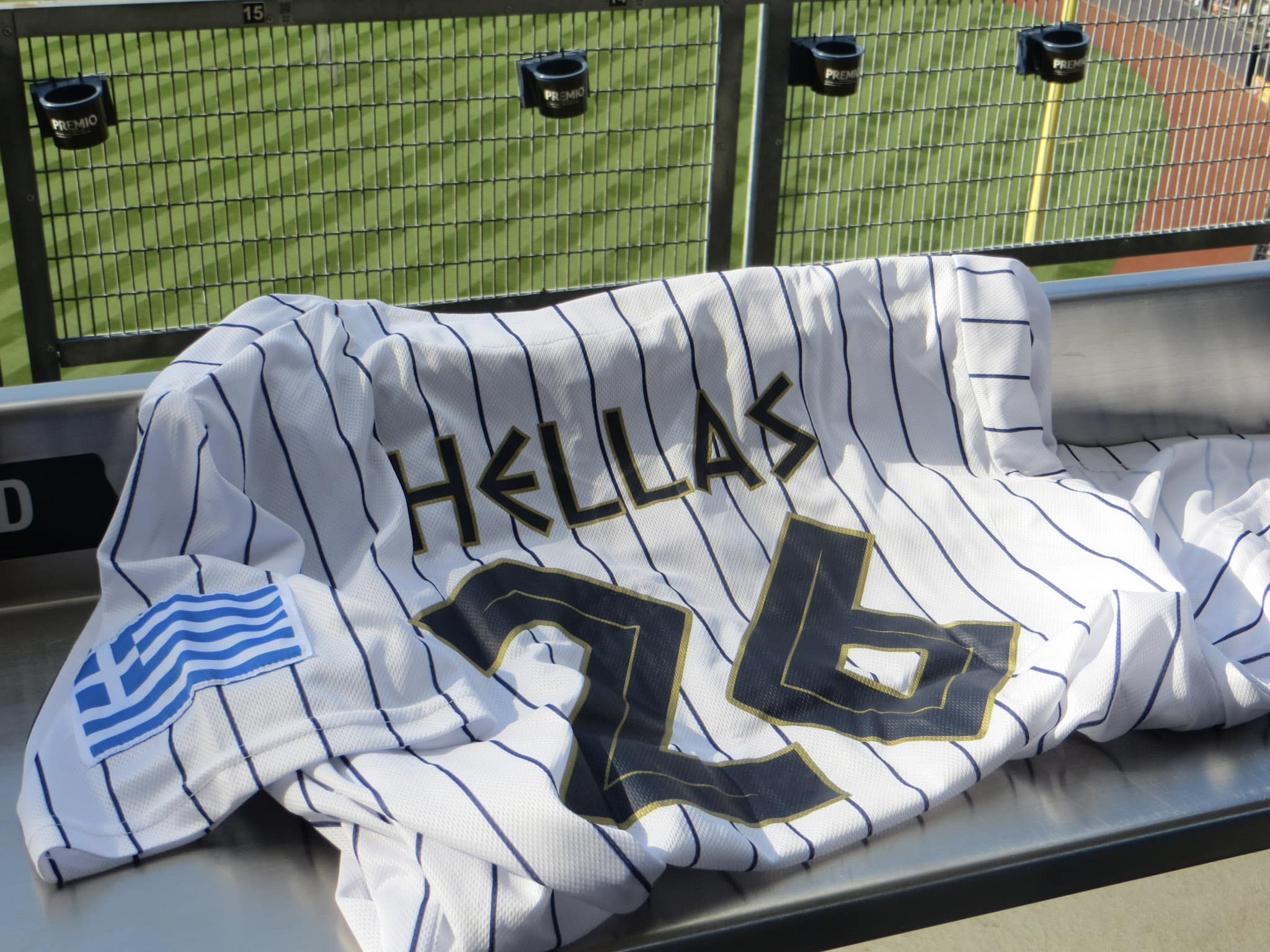 A white pinstriped Greek Yankees jersey with Hellas lettering and a Greek flag patch displayed at Yankee Stadium.