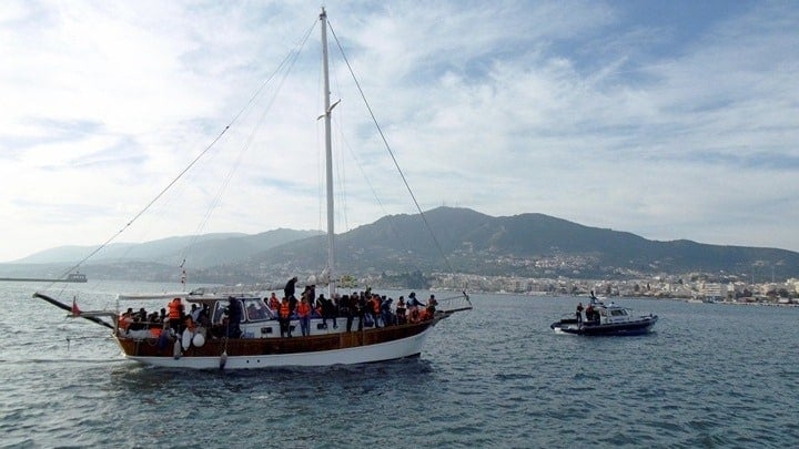 A Hellenic Coast Guard vessel tows a migrant boat to the port. Greece has approved a new migration bill.