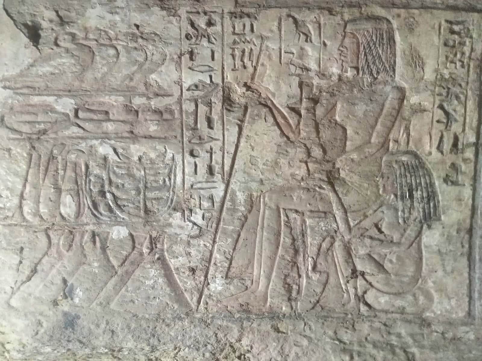 Hieroglyphic inscriptions and carved figures survive on the wall of one of the New Kingdom tombs