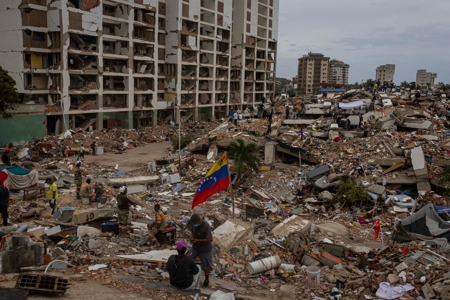Venezuelan flag amid rubble and collapsed buildings after deadly earthquakes in Venezuela.