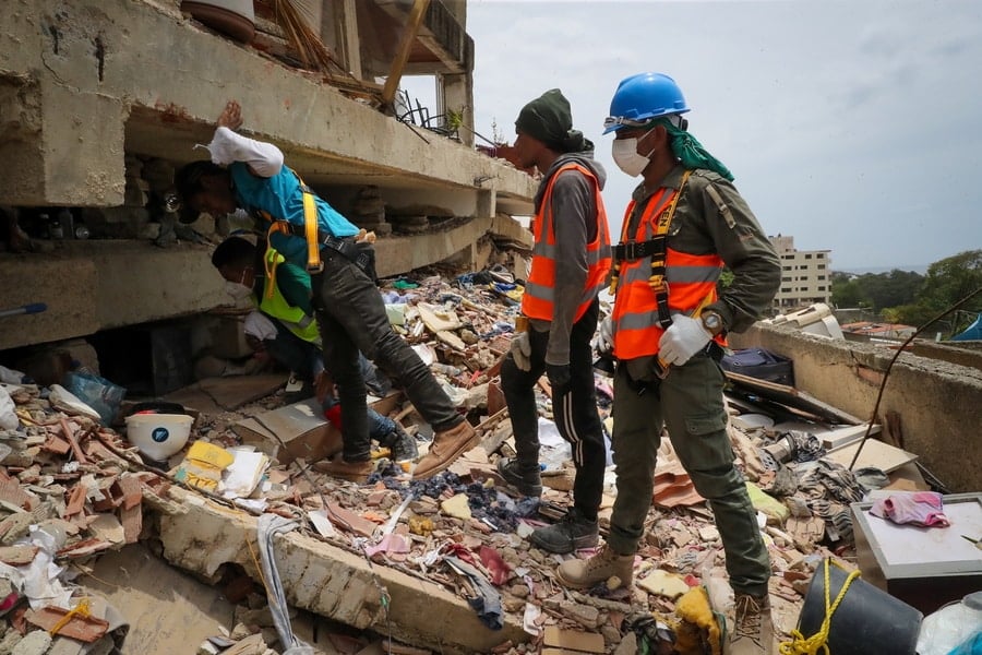 Rescue workers search through earthquake rubble in Venezuela