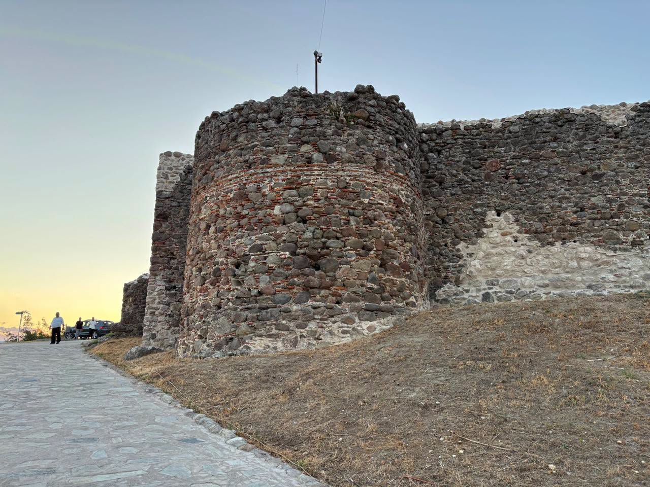 Restored stone walls and a circular defensive tower at Moglena Castle in Pella, northern Greece.