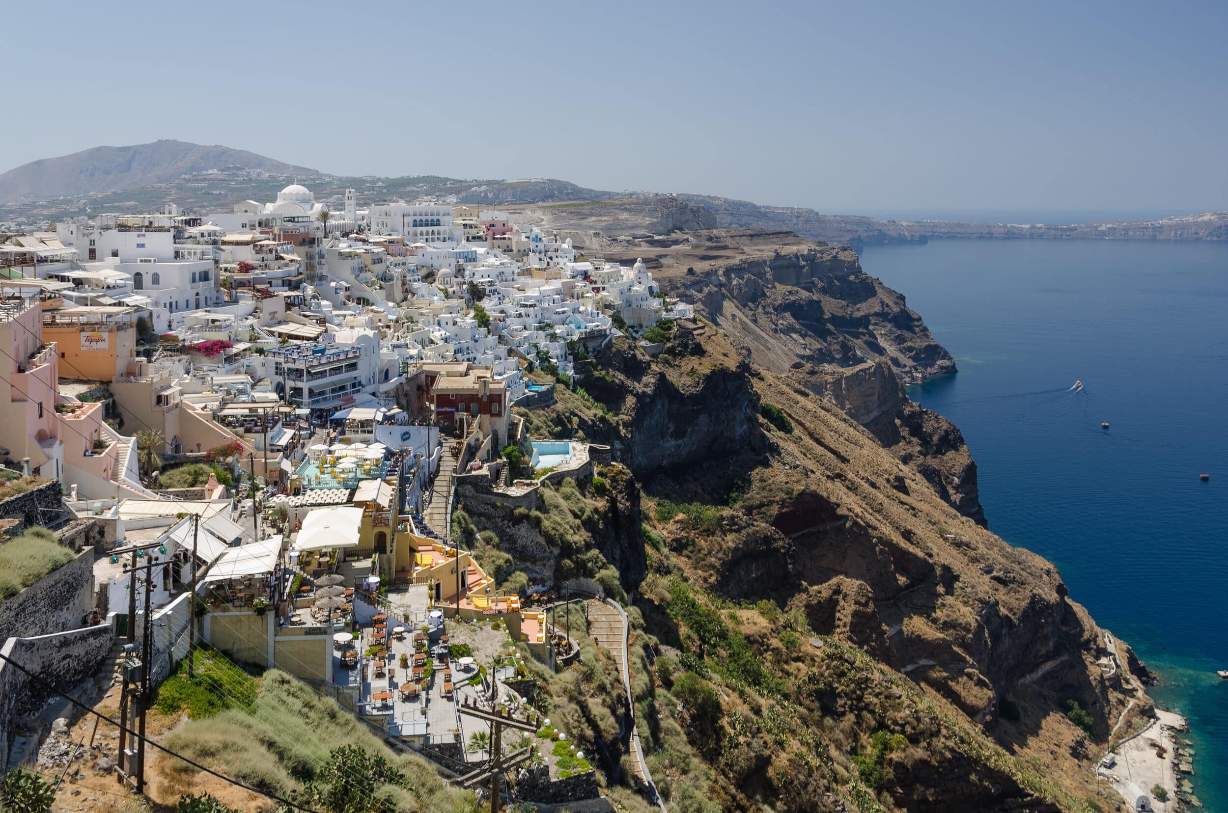 Volcanic cliffs and Fira overlooking the caldera shaped by volcanoes in Santorini, Greece.