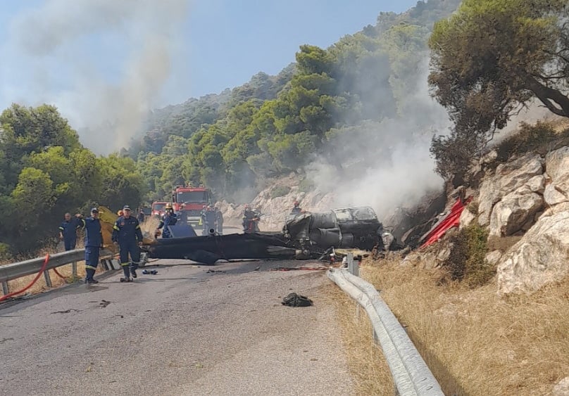 Firefighters work at the site where firefighting helicopters crashed, during a fire in the wider region of Megara, West Attica, Greece
