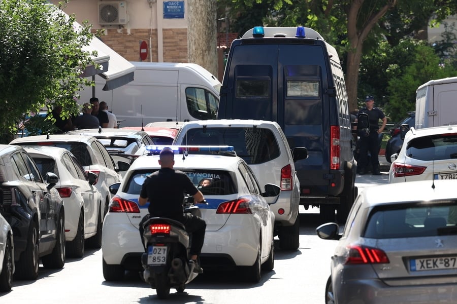 Greek police escort the Marfin arson case suspect in Athens following her extradition from the UK.