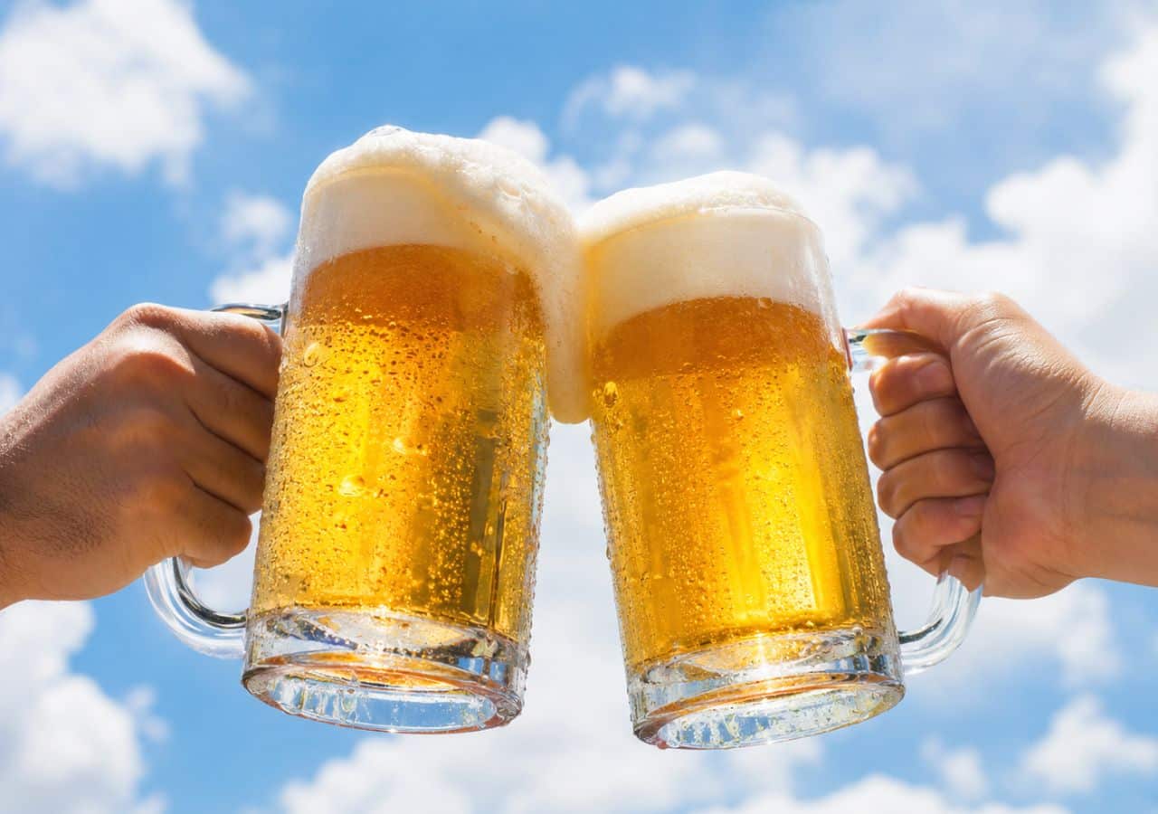 Two person holding Greek beers