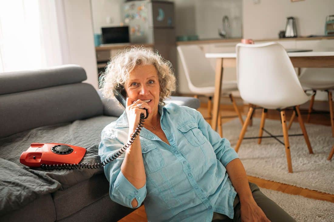 Senior woman engaged in conversation on an old fashioned telephone