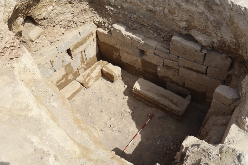 Stone walls and architectural remains inside the newly excavated Etruscan tomb at Vulci