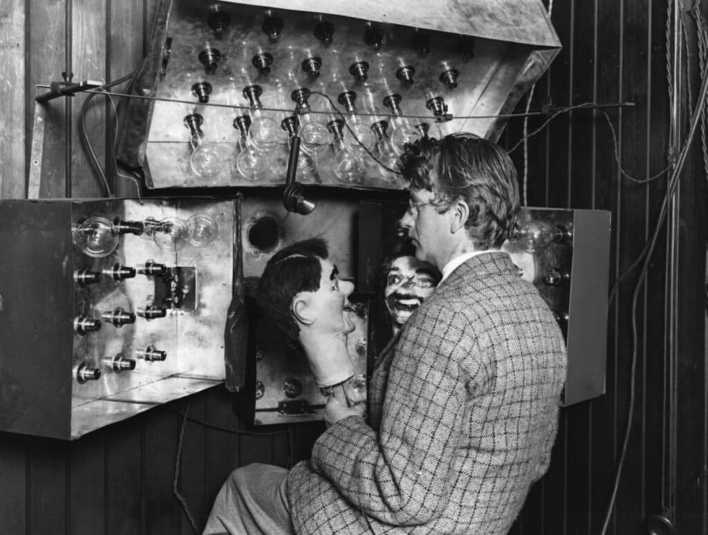 John Logie Baird works with his experimental television apparatus and the dummy Stooky Bill during his early television experiments.