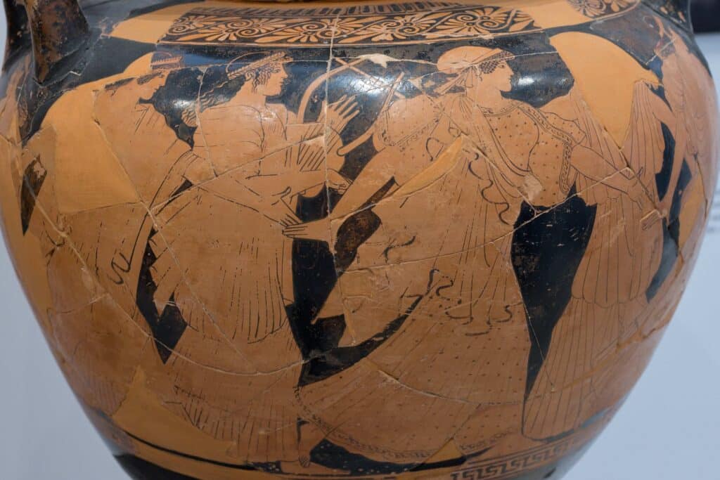 Painted figures on a restored ancient Greek wedding vase, including a seated figure holding a lyre.