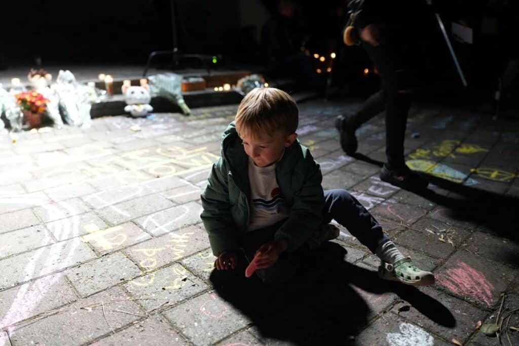 A child pays tribute at a memorial for school shooting victims in Oregon.