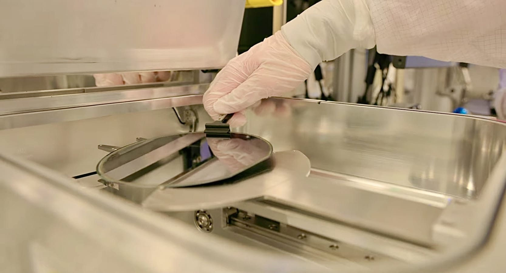 Worker removing a semiconductor wafer from processing equipment