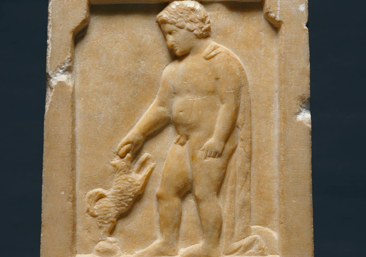 A Greek tombstone dating to about 375 B.C. depicts a young boy named Moschion holding a bird toward his small dog as it jumps up to reach him